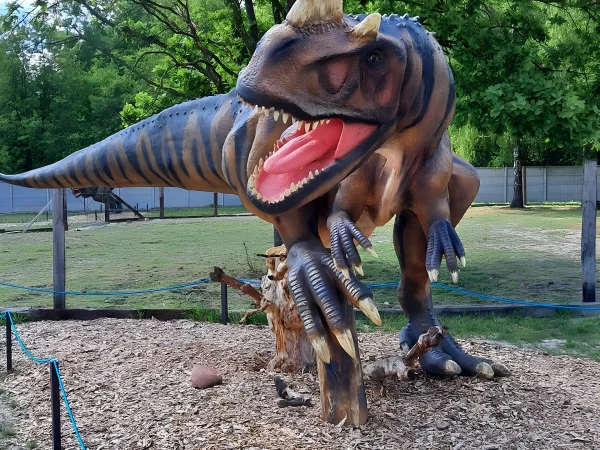 Figura drapieżnego dinozaura z rogiem na nosie i otwartą paszczą