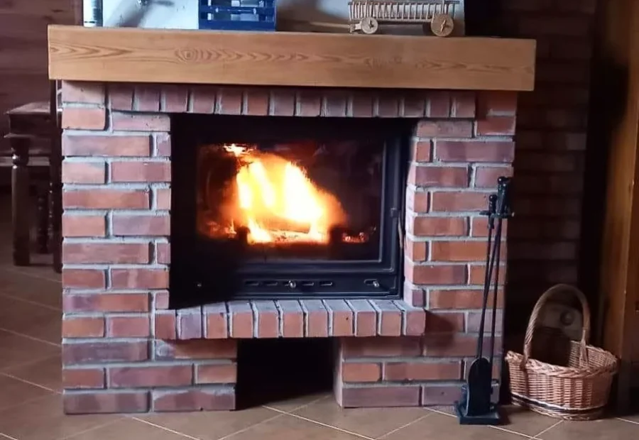 Kominek z płonącym ogniem w salonie domku